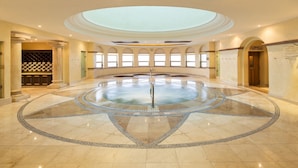 A circular hot tub with a central pole, surrounded by a tiled floor with a decorative border. - Luxury 2BR Suite at Villa La Estancia – Beachfront Pools, Spa & Sunsets (Cabo San Lucas)