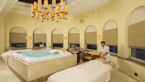 A spa room with a hot tub, massage tables, and a person receiving a massage. - Luxury 2BR Suite at Villa La Estancia – Beachfront Pools, Spa & Sunsets (Cabo San Lucas)