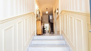 Una escalera con paredes blancas y un armario de madera en la parte superior.