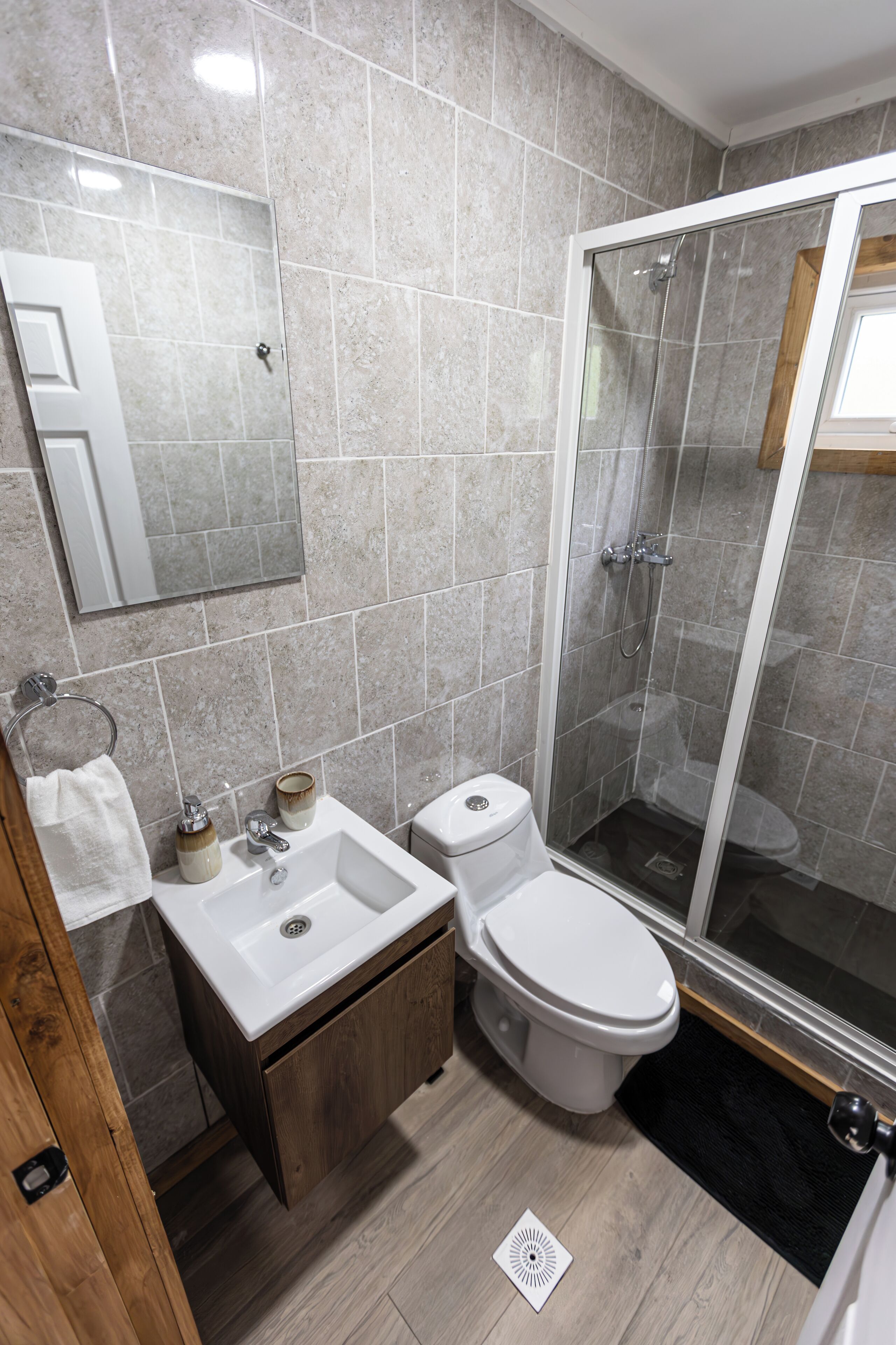 A bathroom with a toilet, sink, and shower.