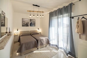 A modern bedroom with a large bed, bedside lamps, and a view of the outdoors through sheer curtains. - DreamFrame, a fantastic holiday in Agerola next to the Path of (Pianillo)