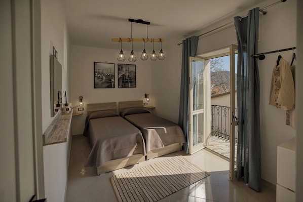 A bedroom with two beds, a balcony with a view, and a large window. - DreamFrame, a fantastic holiday in Agerola next to the Path of (Pianillo)