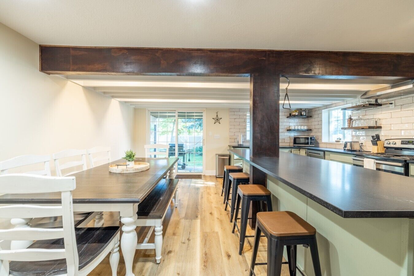 Une cuisine moderne dotée d’un îlot central, de tabourets de bar et d’une table à manger avec des chaises.