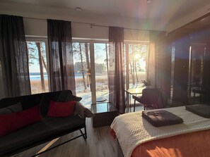 Un dormitorio moderno con una cama grande, un sofá y una mesa de comedor.