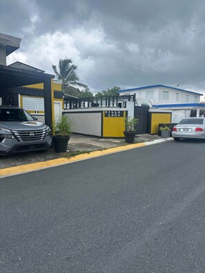 A gated entrance to a property named 'Villa Lago' with a grey car parked in front. - Villa Piscina #5 en Levittown Toa baja (Levittown)