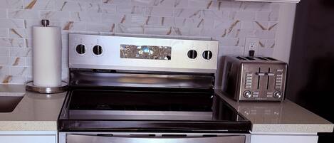 A kitchen with a stainless steel stove, oven, microwave, and toaster.
