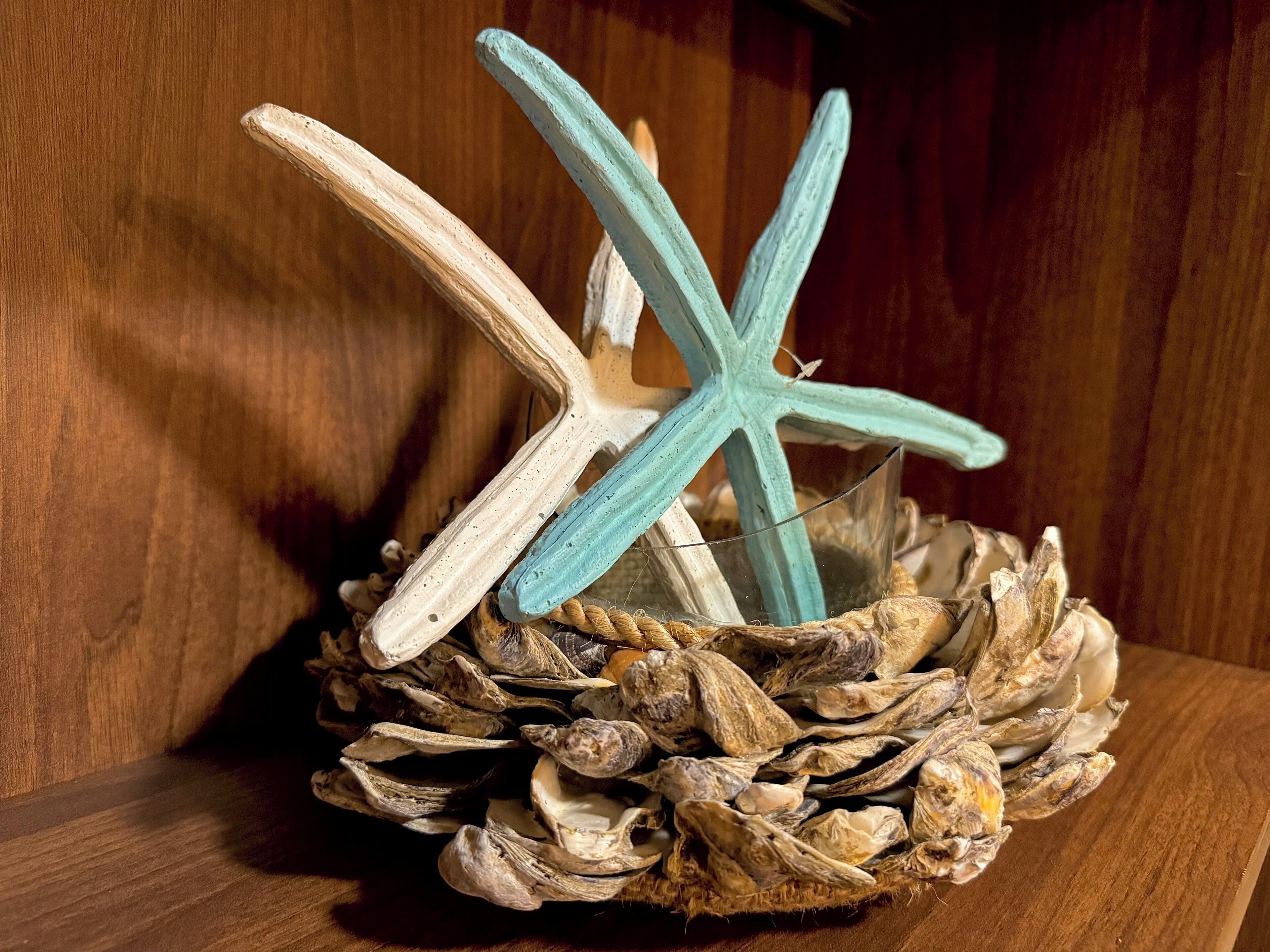 A decorative arrangement of starfish and driftwood in a woven basket.