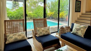 A room with a pool view, two sofas, and a staircase. - Prestige Golf Villa Privad Pool Privad Pool vista cana- Punta cana (Punta Cana)