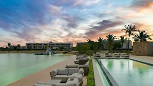A pool area with lounge chairs, a wooden deck, and a view of buildings in the background. - Prestige Golf Villa Privad Pool Privad Pool vista cana- Punta cana (Punta Cana)