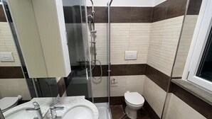 Un bagno moderno dotato di due lavabi, un bidet, un WC e un box doccia.