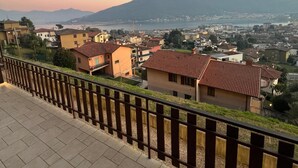 Un quartiere residenziale con case, cielo sereno e montagne in lontananza.
