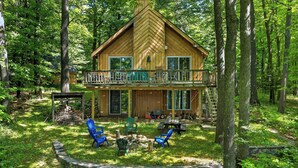 Eine Holzhütte mit einem Balkon, umgeben von Bäumen.