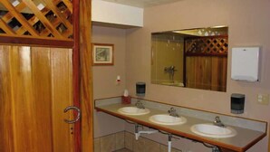 Un baño con dos lavamanos, un espejo y una puerta de madera.