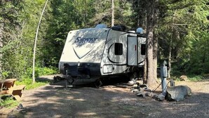 A recreational vehicle (RV) parked in a wooded area. - Cute Camper on FHU Site in Beautiful Campground (Hungry Horse)