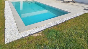A modern house with a swimming pool, outdoor seating, and a clear sky. - One of a kind villa 2+1 guests with heated pool and indoor wellness area (Svetvincenat)