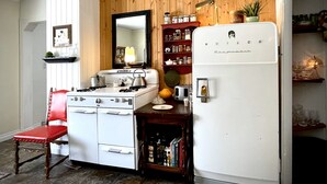 Eine Küche mit einem weißen Herd, einem Kühlschrank und einer Holzwand.