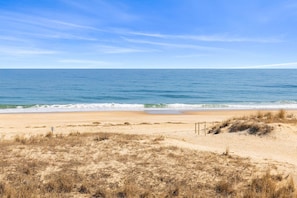 Una platja amb cel blau clar i mar tranquil·la.