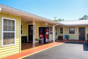 A yellow building with a covered entrance, a sign reading 'OFFICE,' and two vending machines. - Riviera Motel Elba Near Enterprise US 84 (Elba)