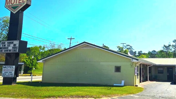 A motel with a sign indicating amenities like parking, king-size beds, and a microwave. - Riviera Motel Elba Near Enterprise US 84 (Elba)