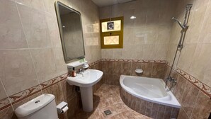 Une salle de bain avec des toilettes, un lavabo et une baignoire.