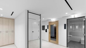 A modern hotel lobby with a glass partition, wooden wardrobe, and a glass shower room. - City Vibes with Spa & Gym in Sleek 1BR Retreat (Miami)