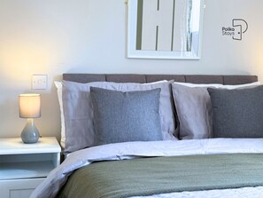 Escritorio, tabla de planchar con plancha, wifi y ropa de cama