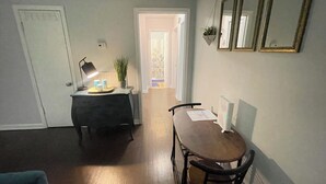 A dining area with a table and chairs, a lamp, a potted plant, and a computer on the table. - Deck the Halls (Clarksville)