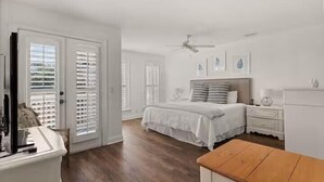 A bedroom with a bed, a nightstand, a dresser, and a ceiling fan. - Large beach home w golf cart, minutes from beach! (St Simons Island)