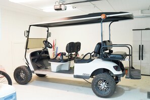 A white golf cart with a black seat, black handlebars, and a black canopy. - Large beach home w golf cart, minutes from beach! (St Simons Island)