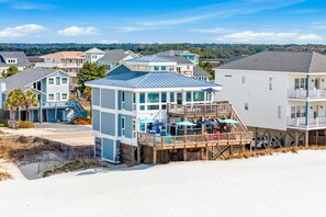 A beachfront property with a beach house, a wooden deck, and a view of the ocean. - Bonsai - Oceanfront Zen Retreat • 4BR • 5BA • Direct Beach Walkway • Epic Views (Oak Island)