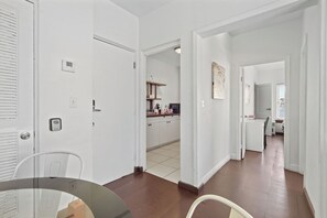Un appartement moderne comprenant une cuisine, un coin repas et un couloir menant au salon.