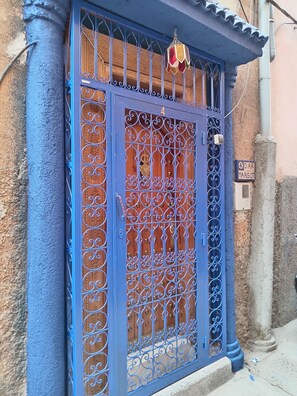 A blue metal gate with intricate designs, a wooden door, and a sign indicating the address. - DAR MARGOT MARRAKECH (Marrakesh)