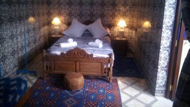 A traditional room with a bed, two bedside lamps, patterned walls, and a decorative rug. - DAR MARGOT MARRAKECH (Marrakesh)