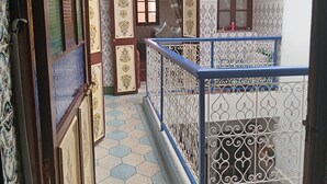 A corridor with a patterned floor, decorative doors, and a balcony with a metal railing. - DAR MARGOT MARRAKECH (Marrakesh)