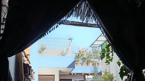 An entrance with a patterned rug, a red door, and potted plants. - DAR MARGOT MARRAKECH (Marrakesh)
