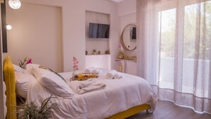 Une chambre à coucher avec un lit, une télévision, un miroir et une fenêtre avec des rideaux.