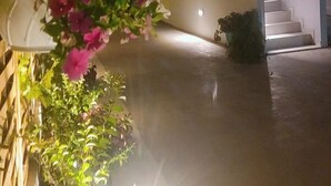 Um edifício com vários níveis, uma escadaria, um arranjo de flores pendente e um candeeiro fixado na parede.