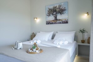 A hotel room with a bed, a painting of a tree, and a small plant on the nightstand. - Diana s House 3 - Gytheio Sandy Beach Haven (East Mani)