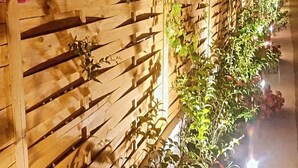 Uma cerca de madeira com plantas trepadeiras e flores.