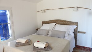 Ein ordentlich bezogenes Bett mit Kopfteil, Kissen und Handtüchern.