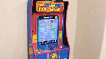 Une borne d’arcade ancienne, dotée d’un design coloré et proposant une sélection de jeux.