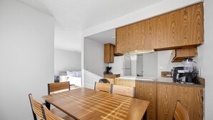 Eine moderne Küche mit Holzschnitzereien, einer zentralen Kochinsel und einem Essbereich mit Esstisch und Stühlen.