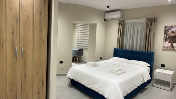 Une chambre à coucher avec un lit, un bureau et une armoire.