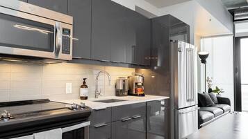 A modern kitchen with stainless steel appliances, a built-in oven, and a coffee maker.