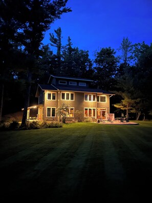 A two-story house with a well-maintained lawn and a driveway leading to the front door.