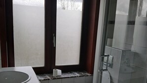 Ett badrum med toalett, handfat och en duschhörna.