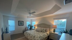 A bedroom with a bed, bedside tables, a ceiling fan, and a window with blinds. - GORGEOUS 3-bedroom house with NEW golf cart in The Villages! Perfect location! (The Villages)