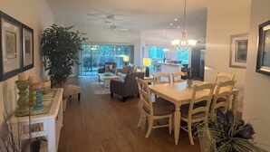 A spacious living area with a dining table, chairs, a ceiling fan, and a large potted plant. - GORGEOUS 3-bedroom house with NEW golf cart in The Villages! Perfect location! (The Villages)