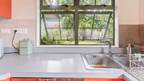 Eine Küche mit Fenster, Spüle und Kompostbehälter.