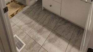 Un baño con inodoro, lavamanos y zona de ducha.